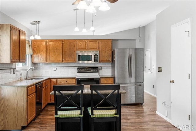459 Xavier Ct, Valley Park, MO 63088 - kitchen with appliances with stainless steel finishes, a sink, tasteful backsplash, dark wood finished floors, and vaulted ceiling