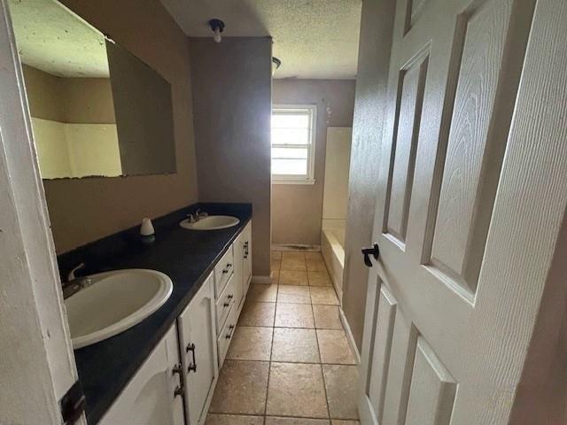 15606 County Road 624, Dexter, MO 63841 - full bathroom featuring a textured ceiling, double vanity, and shower / tub combination