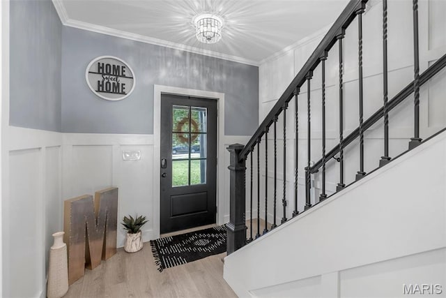 28 Millwell Dr, Maryland Heights, MO 63043 - foyer entrance with crown molding, wood finished floors, a decorative wall, stairs, and a wainscoted wall