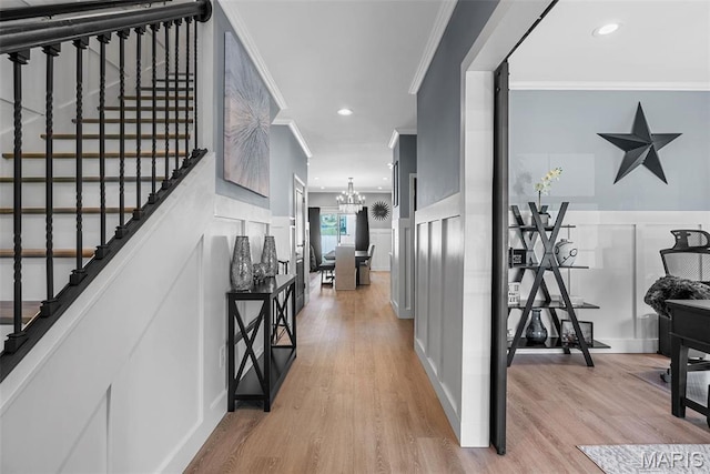 28 Millwell Dr, Maryland Heights, MO 63043 - hall featuring a decorative wall, ornamental molding, light wood finished floors, stairs, and a chandelier