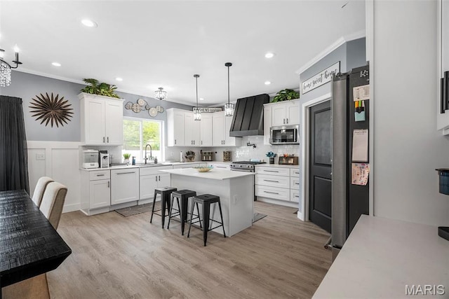 28 Millwell Dr, Maryland Heights, MO 63043 - kitchen with premium range hood, stainless steel appliances, crown molding, light countertops, and a kitchen bar