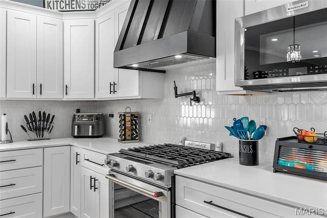 28 Millwell Dr, Maryland Heights, MO 63043 - kitchen featuring wall chimney range hood, stainless steel appliances, backsplash, white cabinets, and light countertops