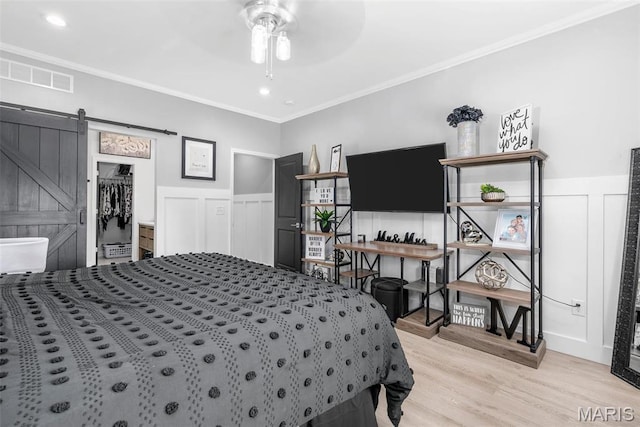 28 Millwell Dr, Maryland Heights, MO 63043 - bedroom featuring light wood-style flooring, wainscoting, a barn door, crown molding, and a decorative wall