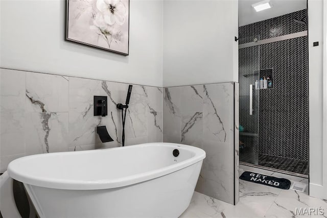 28 Millwell Dr, Maryland Heights, MO 63043 - bathroom with tile walls, marble tiled flooring, a stall shower, a freestanding tub, and wainscoting