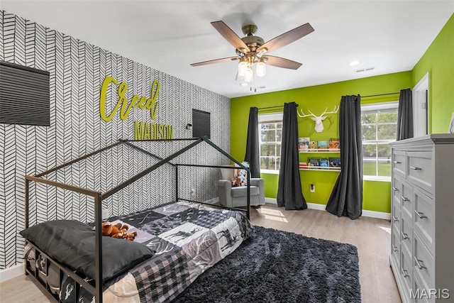 28 Millwell Dr, Maryland Heights, MO 63043 - bedroom featuring an accent wall, wallpapered walls, multiple windows, light wood-type flooring, and recessed lighting