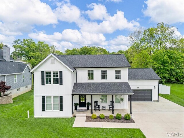 28 Millwell Dr, Maryland Heights, MO 63043 - view of front of property featuring a porch, roof with shingles, a garage, concrete driveway, and a front lawn
