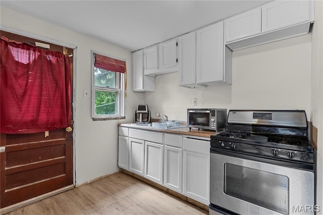 1937 N Hanley Rd, Saint Louis, MO 63114 - kitchen featuring stainless steel gas range, light wood finished floors, white cabinets, and light countertops