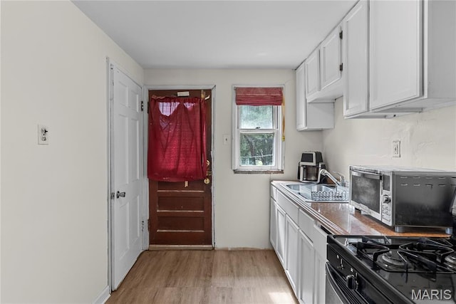 1937 N Hanley Rd, Saint Louis, MO 63114 - kitchen featuring gas range, white cabinetry, and light wood-style flooring