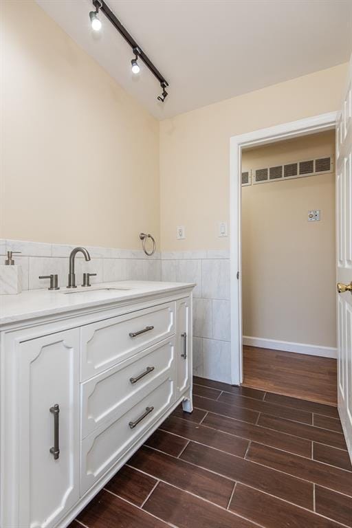 505 Stephanie Ln, Manchester, MO 63011 - bathroom featuring tile walls, vanity, wood tiled floors, wainscoting, and track lighting