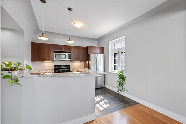 603 Westgate Ave Unit 603E, Saint Louis, MO 63130 - kitchen with stainless steel appliances, baseboards, hanging light fixtures, a peninsula, and light stone countertops