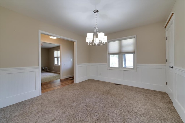 204 Chestnut Dr, Saint Charles, MO 63301 - carpeted spare room with a chandelier and wainscoting