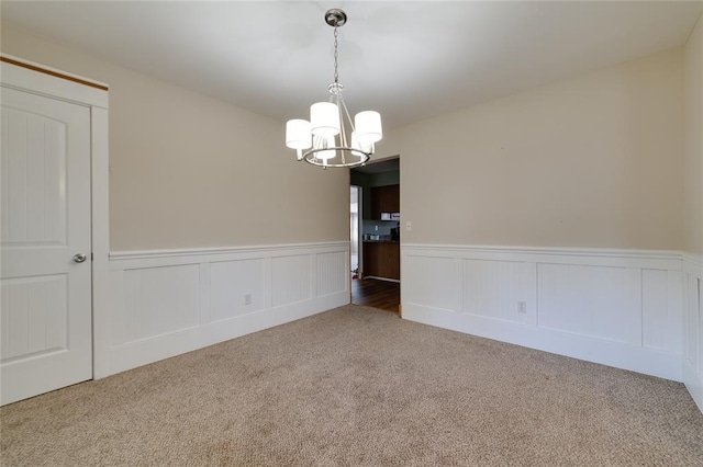 204 Chestnut Dr, Saint Charles, MO 63301 - spare room with carpet flooring, a chandelier, and a wainscoted wall