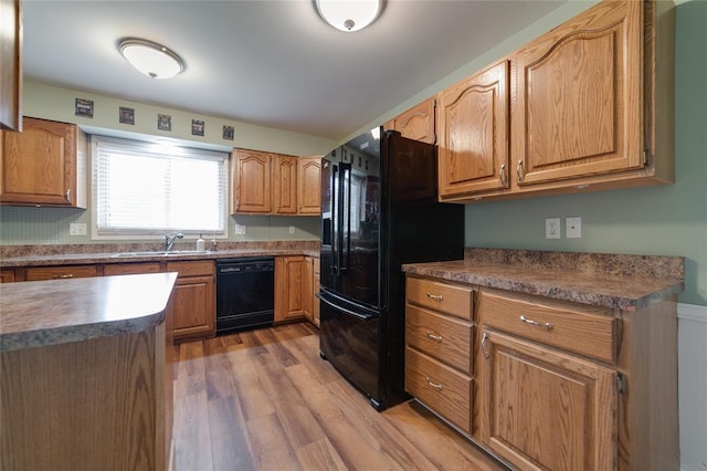 204 Chestnut Dr, Saint Charles, MO 63301 - kitchen featuring black appliances, a sink, wood finished floors, and brown cabinets