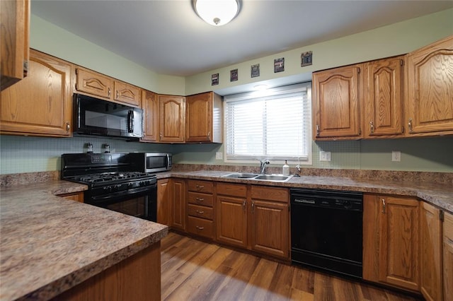 204 Chestnut Dr, Saint Charles, MO 63301 - kitchen featuring black appliances, a sink, brown cabinetry, and dark wood-type flooring