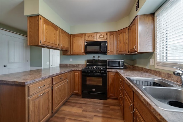 204 Chestnut Dr, Saint Charles, MO 63301 - kitchen with black appliances, a sink, brown cabinetry, and dark wood-style flooring