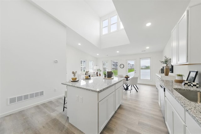 4001 Marais Temps Clair Dr, Saint Charles, MO 63304 - kitchen with plenty of natural light, a kitchen island, light wood-style flooring, white cabinetry, and recessed lighting