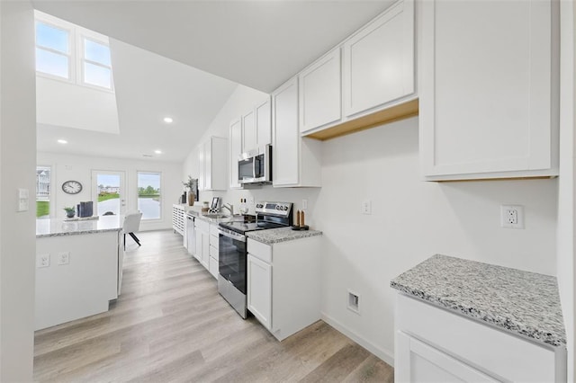 4001 Marais Temps Clair Dr, Saint Charles, MO 63304 - kitchen with stainless steel appliances, white cabinets, light wood finished floors, a sink, and recessed lighting