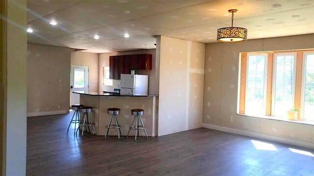 2357 Pine St, Centerville, MO 63633 - kitchen featuring freestanding refrigerator, dark wood-style floors, baseboards, a kitchen bar, and recessed lighting