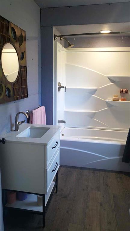 2357 Pine St, Centerville, MO 63633 - bathroom featuring wood finished floors, vanity, and bathtub / shower combination