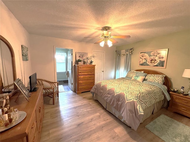 113 Fairway Dr, Maryville, IL 62062 - bedroom featuring a textured ceiling, light wood-style flooring, and a ceiling fan