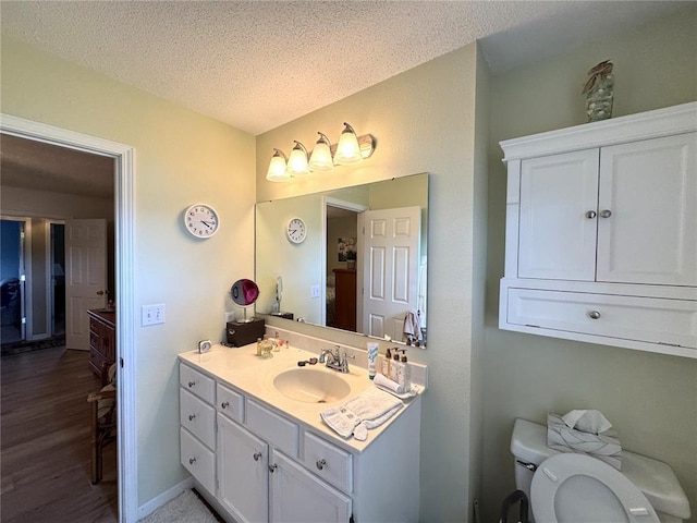 113 Fairway Dr, Maryville, IL 62062 - bathroom featuring toilet, vanity, a textured ceiling, and wood finished floors