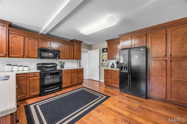 8525 Sagamore Dr, Cedar Hill, MO 63016 - kitchen with black appliances, light countertops, light wood-style floors, tasteful backsplash, and beam ceiling