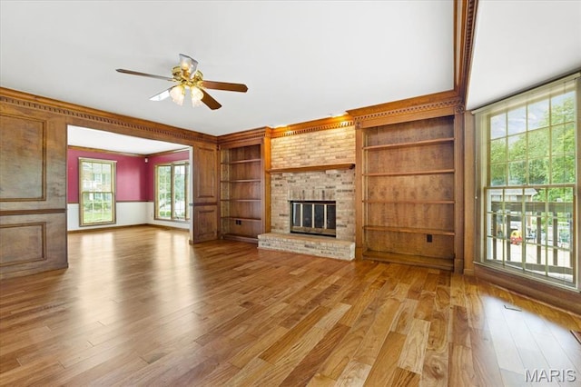 767 Carman Meadows Dr S, Manchester, MO 63021 - unfurnished living room featuring ceiling fan, light wood-style floors, a fireplace, and healthy amount of natural light
