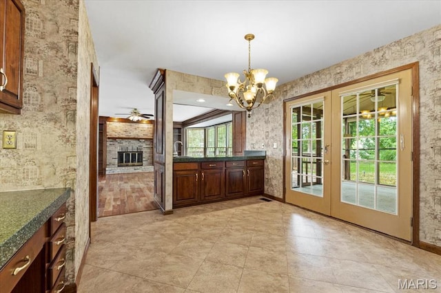 767 Carman Meadows Dr S, Manchester, MO 63021 - unfurnished dining area with french doors, a fireplace, a ceiling fan, and a chandelier