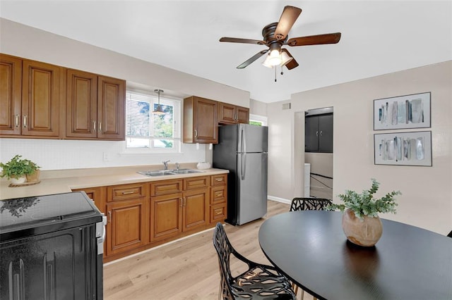 655 5th Plz, Florissant, MO 63031 - kitchen featuring freestanding refrigerator, a sink, light wood finished floors, ceiling fan, and brown cabinets