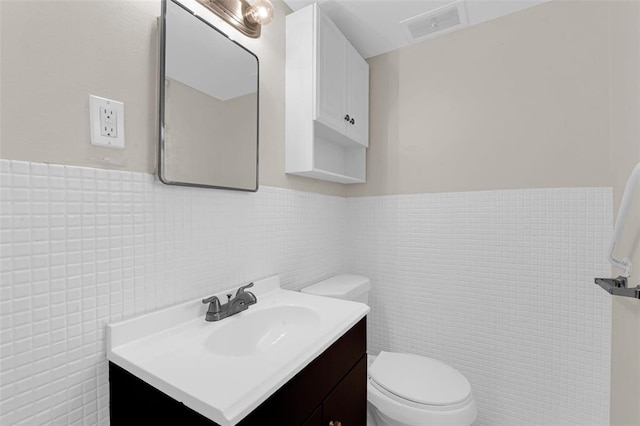 655 5th Plz, Florissant, MO 63031 - bathroom featuring vanity, tile walls, toilet, and wainscoting