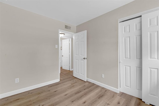 655 5th Plz, Florissant, MO 63031 - unfurnished bedroom featuring baseboards, light wood-type flooring, and a closet