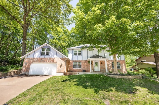 14 Shallowbrook Dr, Ofallon, IL 62269 - tudor-style house with concrete driveway, a garage, a front lawn, and brick siding