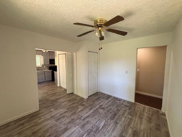 201 Penelope Pl, Olympian Village, MO 63020 - unfurnished room with dark wood-style flooring, a textured ceiling, ceiling fan, and baseboards