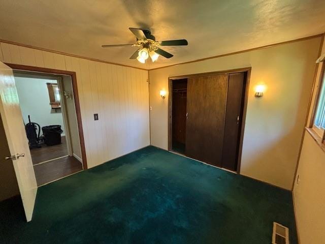 201 Penelope Pl, Olympian Village, MO 63020 - unfurnished bedroom featuring a closet, ceiling fan, and wood walls