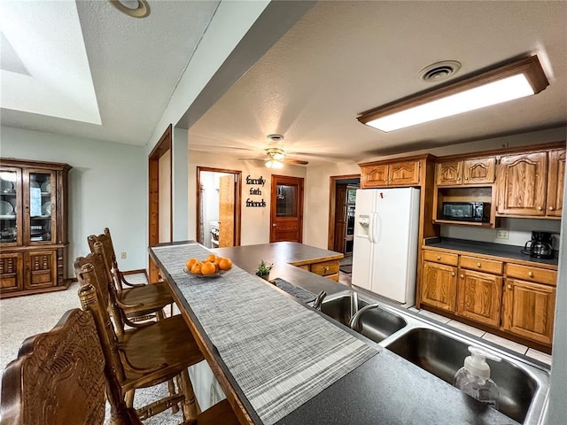 619 Cleveland St, Paris, MO 65275 - kitchen featuring white fridge with ice dispenser, black microwave, dark countertops, and brown cabinets