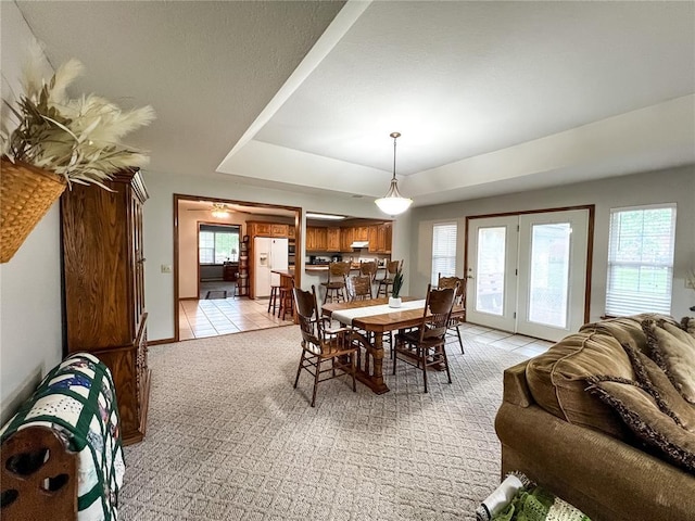 619 Cleveland St, Paris, MO 65275 - dining space with a tray ceiling, light tile patterned floors, light colored carpet, and baseboards