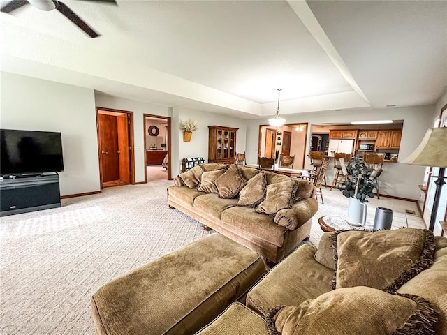 619 Cleveland St, Paris, MO 65275 - living room with light carpet, baseboards, a tray ceiling, and a ceiling fan