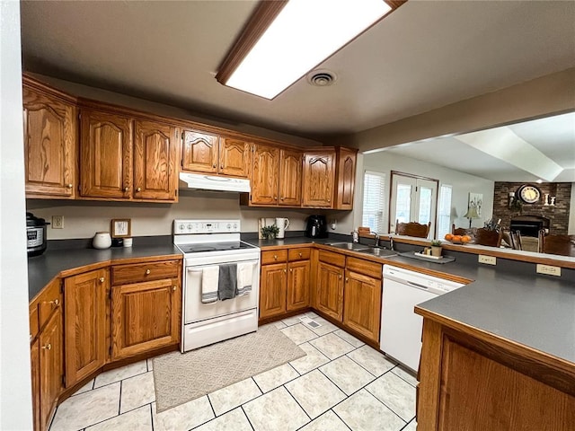 619 Cleveland St, Paris, MO 65275 - kitchen with white appliances, under cabinet range hood, brown cabinets, dark countertops, and light tile patterned flooring