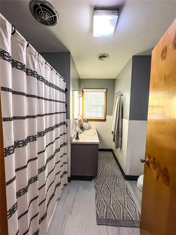 619 Cleveland St, Paris, MO 65275 - bathroom with vanity, toilet, curtained shower, and baseboards
