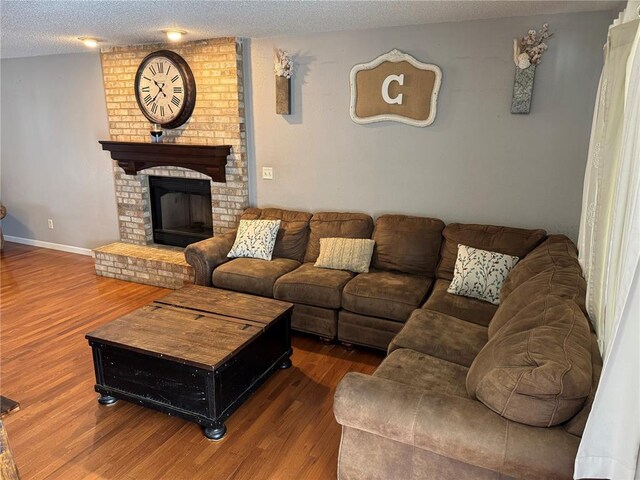 102 Riverview Bend Estates Dr, Crystal City, MO 63019 - living room featuring wood finished floors, a textured ceiling, baseboards, and a fireplace
