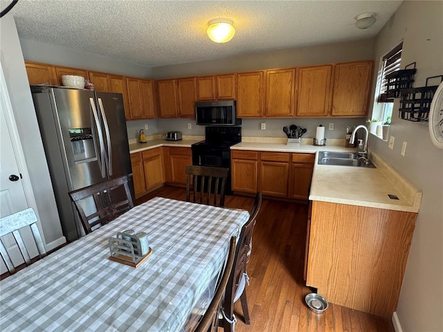 102 Riverview Bend Estates Dr, Crystal City, MO 63019 - kitchen featuring stainless steel appliances, a sink, brown cabinets, dark wood-style flooring, and light countertops