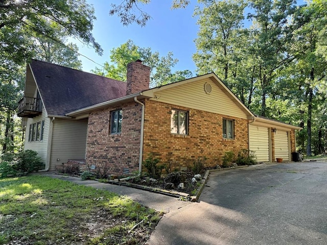 16463 Terrace Dr, Dexter, MO 63841 - view of side of property with a chimney, a garage, driveway, and brick siding
