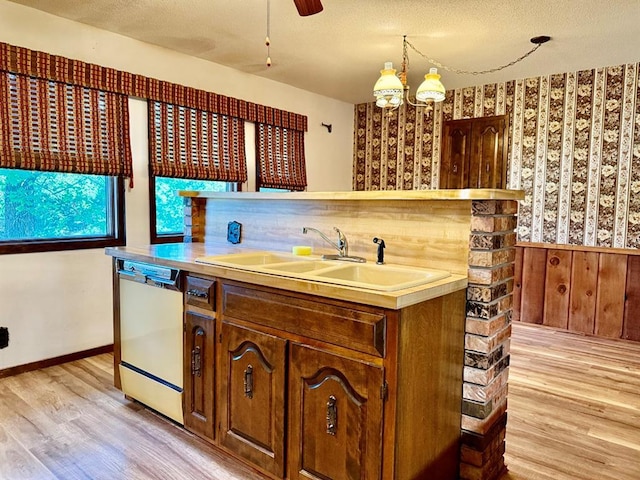 16463 Terrace Dr, Dexter, MO 63841 - kitchen with dishwasher, a sink, light wood-type flooring, wallpapered walls, and light countertops