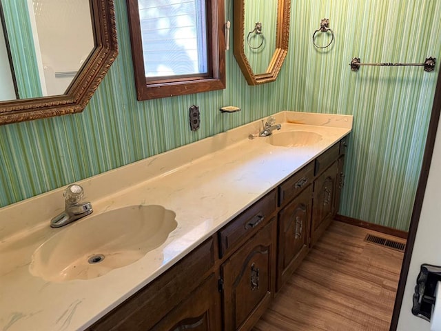 16463 Terrace Dr, Dexter, MO 63841 - full bath with wallpapered walls, double vanity, wood finished floors, and baseboards