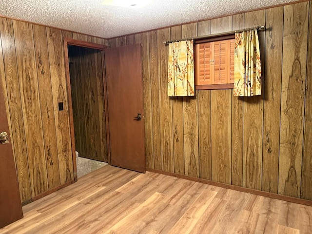 16463 Terrace Dr, Dexter, MO 63841 - empty room with wood finished floors, wooden walls, and a textured ceiling