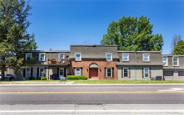 6691 Parker Rd Unit A, Florissant, MO 63033 - view of property with mansard roof, a shingled roof, and a balcony