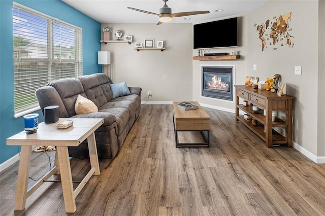 1519 Progress Ln, Belleville, IL 62221 - living room featuring a glass covered fireplace, ceiling fan, baseboards, and wood finished floors