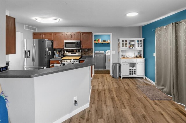 1519 Progress Ln, Belleville, IL 62221 - kitchen featuring stainless steel appliances, dark countertops, washer and dryer, light wood-style flooring, and open shelves