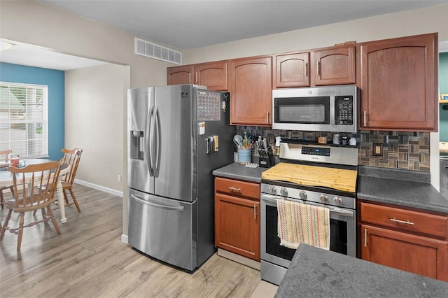 1519 Progress Ln, Belleville, IL 62221 - kitchen featuring stainless steel appliances, light wood finished floors, and dark countertops
