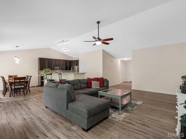 1109 Foxwood Estates Dr, Arnold, MO 63010 - living area with lofted ceiling, a ceiling fan, light wood-style floors, rail lighting, and baseboards